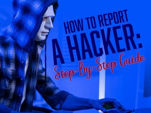 A hacker in a white mask and flannel sweatshirt working on a computer in a dimly lit blue room, symbolizing the threat of cybercrime.
